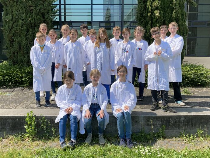 Die IJSO-Juniorforscherinnen und -forscher in Laborkitteln bei den JuniorForscherTagen 2022 auf dem Gutenberg-Campus in Mainz